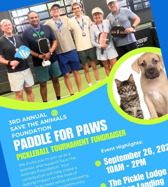 Volunteers posing with pickleball paddles at the Save the Animals Foundation Paddle for Paws fundraiser, with a dog and cat in a circular inset.